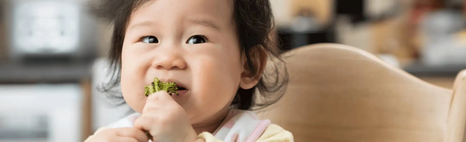 Baby eating broccoli